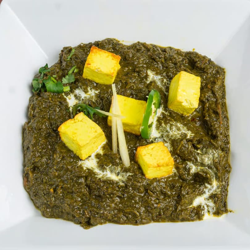 Mehran Restaurant's Palak Paneer, a Pakistani dish with spinach and paneer cheese, garnished with ginger and chili.