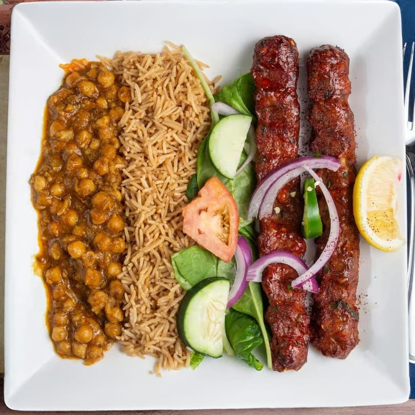 Mehran Restaurant's Seekh Kabob plate with rice, chana masala, salad, and lemon wedge.