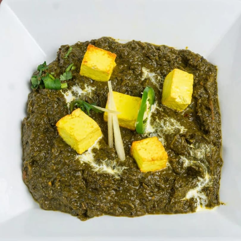 Mehran Restaurant's Palak Paneer, a Pakistani dish with spinach curry, paneer cubes, and ginger garnish.